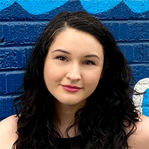 Small headshot of dark haired woman on colorful background